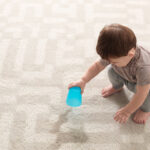 Child spilling drink on new carpet