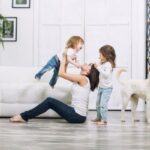 A family with kids and a pet playing on the floor