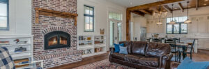 a room with a fireplace, chairs and a couch. on the floor is an ornate area rug