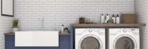 A photo showing a large sink, washer, and dryer on hardwood flooring.