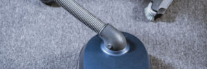 Man with vacuum cleaner cleaning carpeting