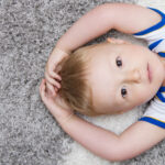 cute baby lying on back on carpet