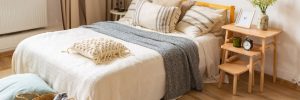 Bed in bedroom above hardwood flooring