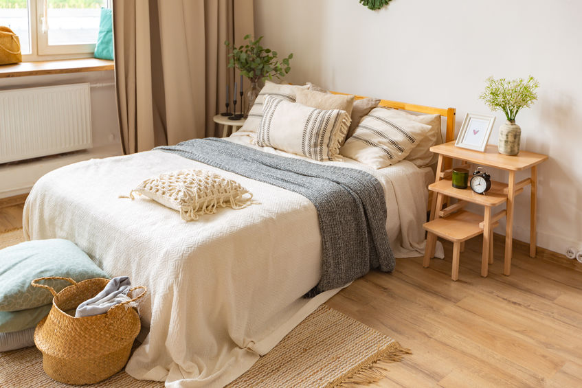 Bed in bedroom above hardwood flooring