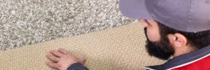 Male worker installing a new carpet
